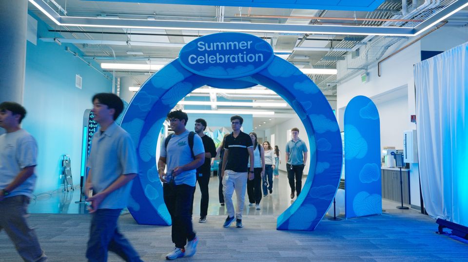 Participants walking through the Summer Celebration arch