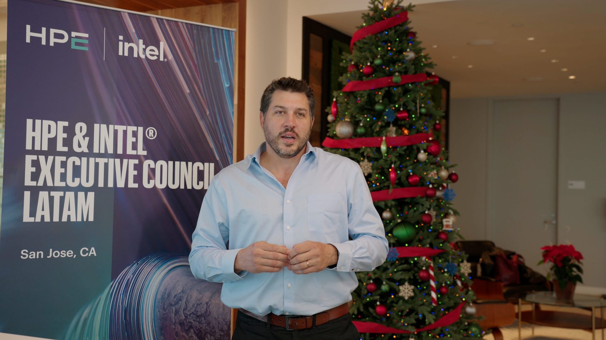 Executive speaking in front of an HPE and Intel Executive Council banner