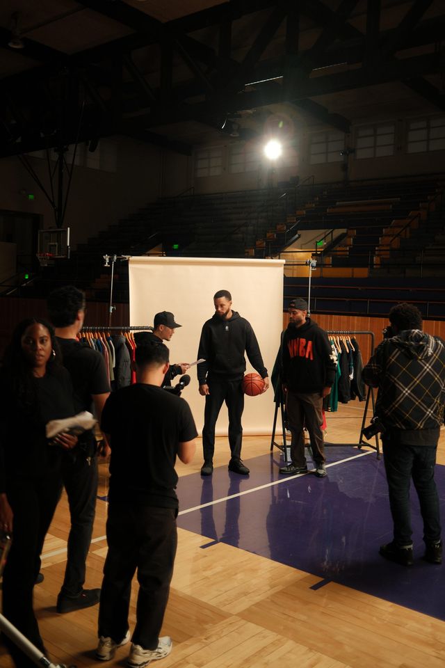 Crew gathered around a camera on the gym set
