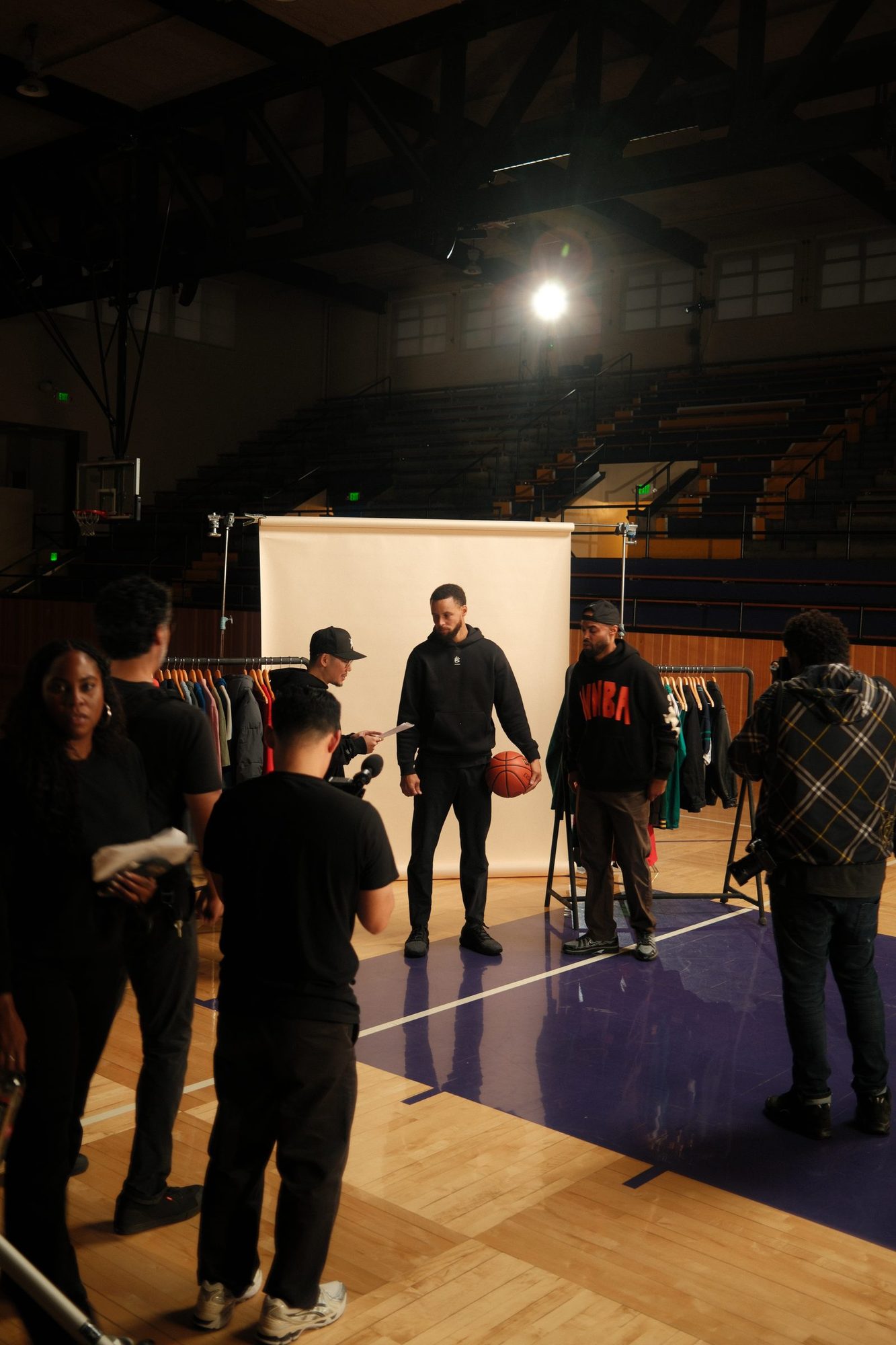 Crew gathered around a camera on the gym set